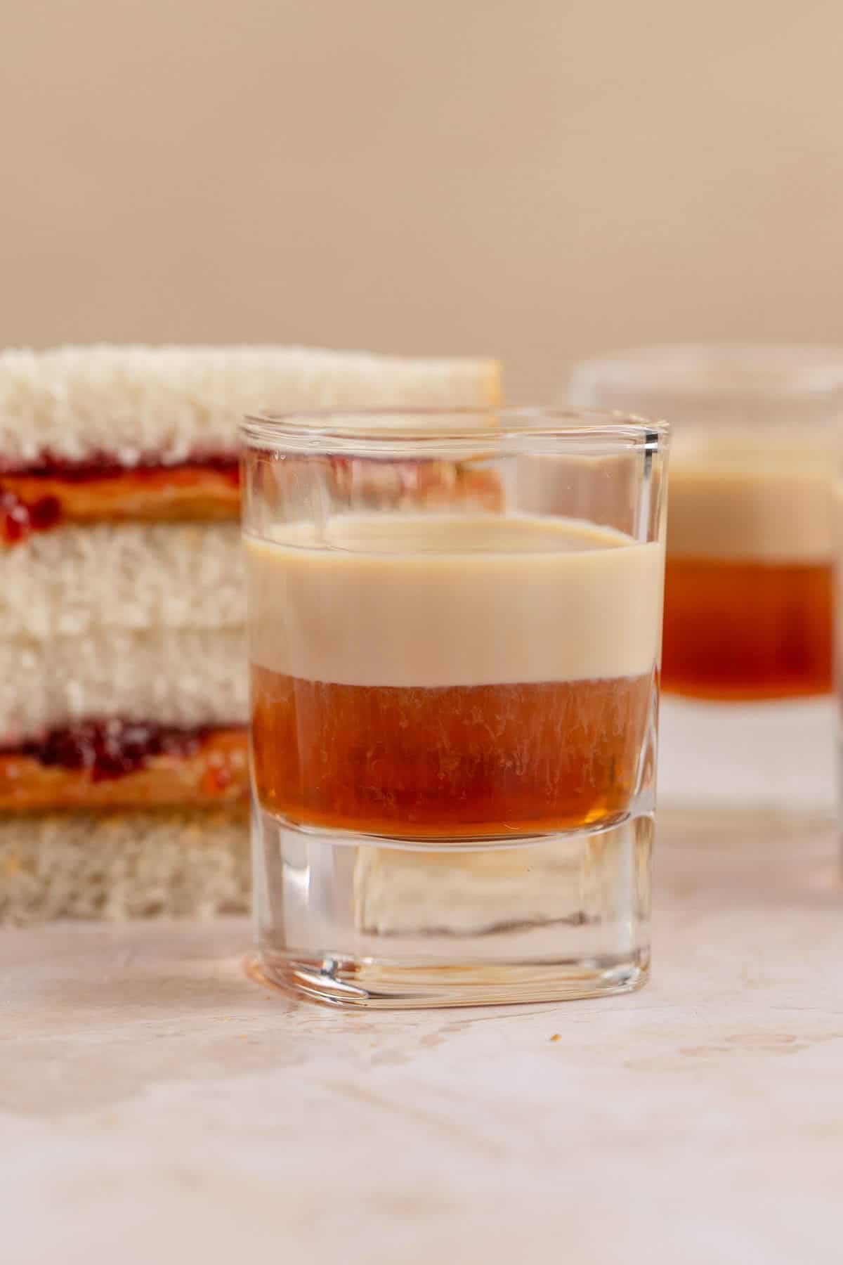 Peanut Butter and Jelly Shot on a counter with a sandwich stacked beside it close up