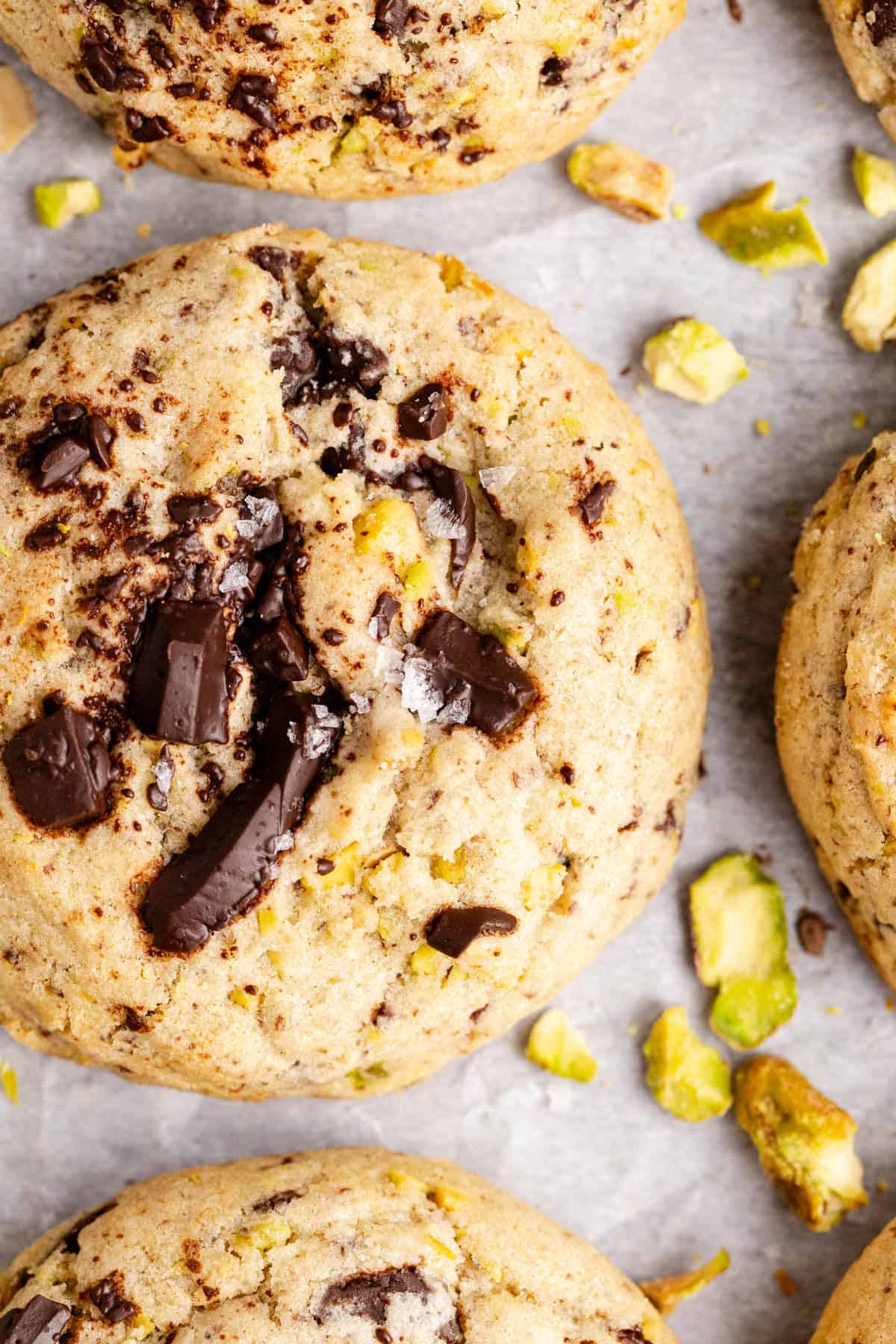 Pistachio Chocolate Chip Cookies on parchment paper up close