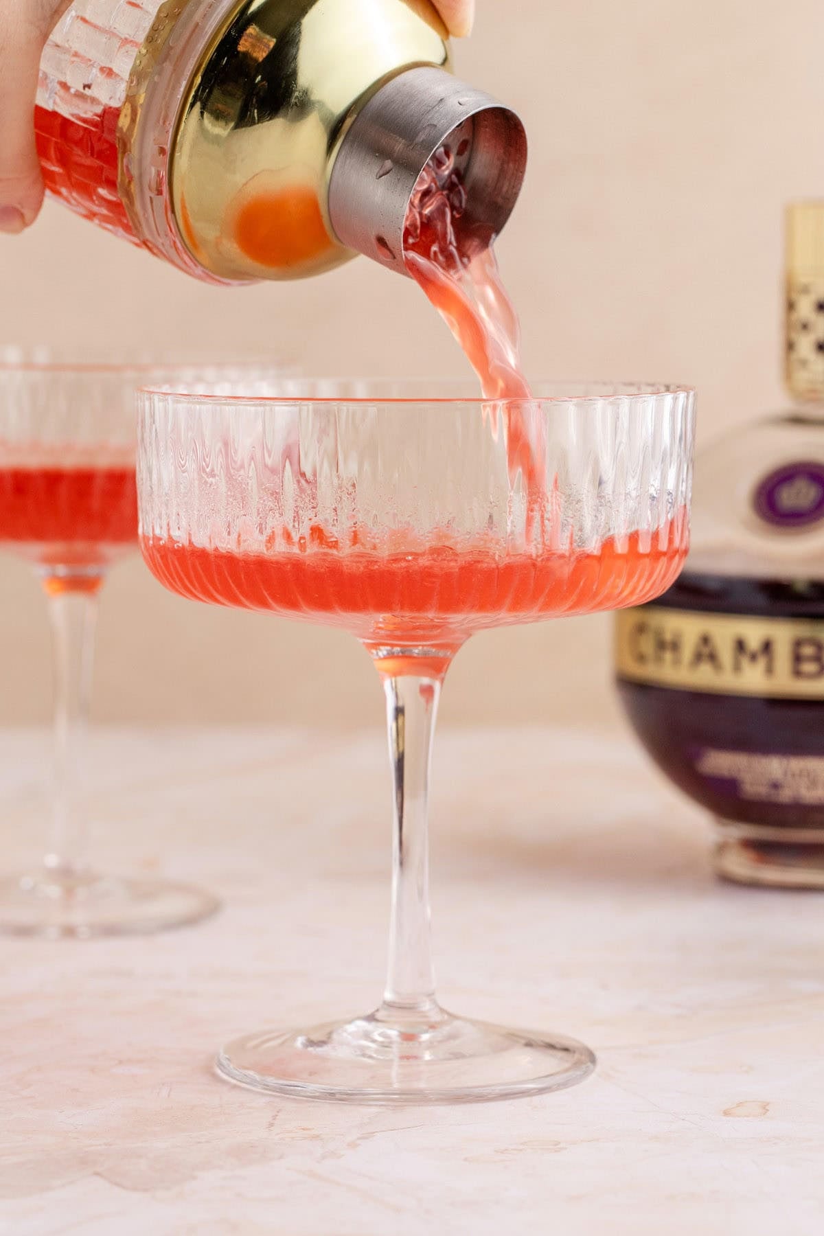 Raspberry Martini being poured in a coup glass