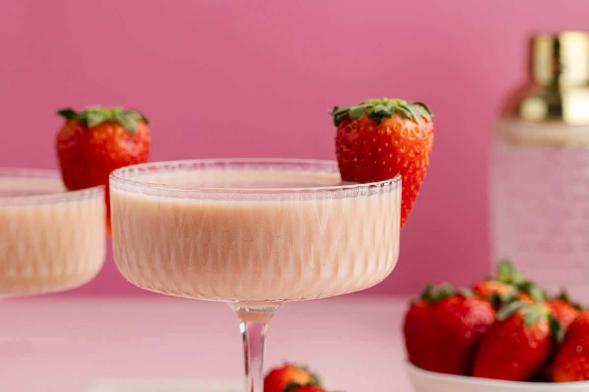 Strawberries and Cream Martini close up with a cocktail shaker in the back