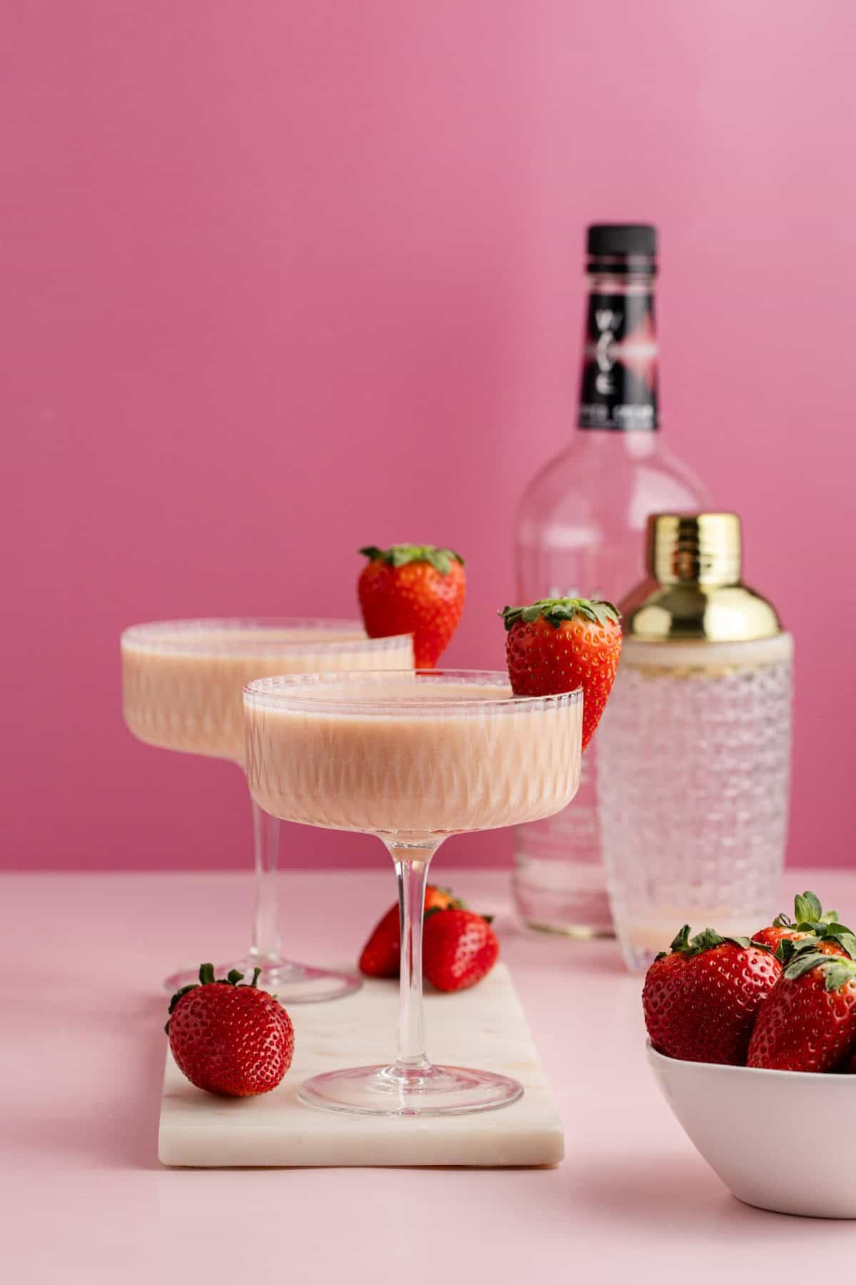 Strawberries and Cream Martini in coup glasses a a berry garnish