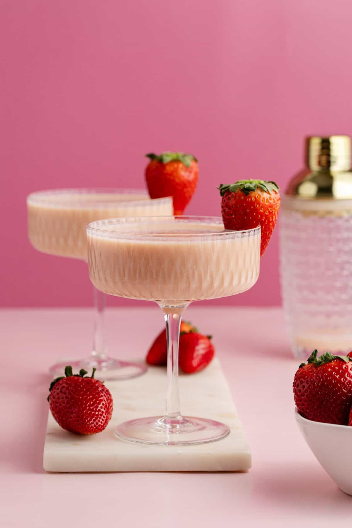 Strawberries and Cream Martini in coup glasses on a cutting board