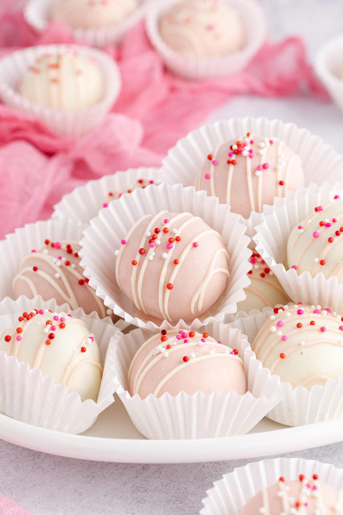 Valentine’s Day Truffles in white sleeves piled on a platter