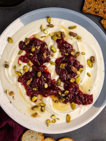 Whipped Goat Cheese in a bowl garnished from above with crackers around