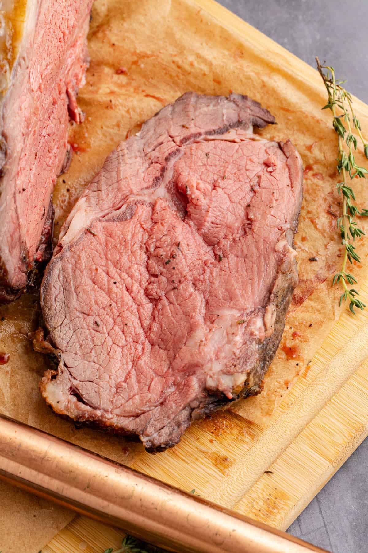 Bone In Prime Rib Roast on a cutting board with a piece sliced
