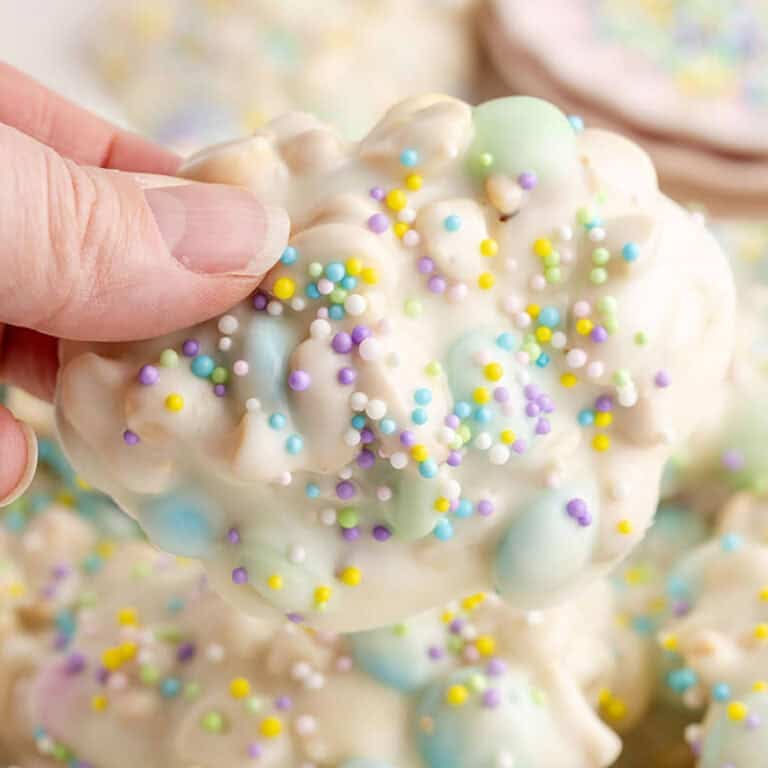Crockpot Easter Candy Clusters with sprinkles being picked up