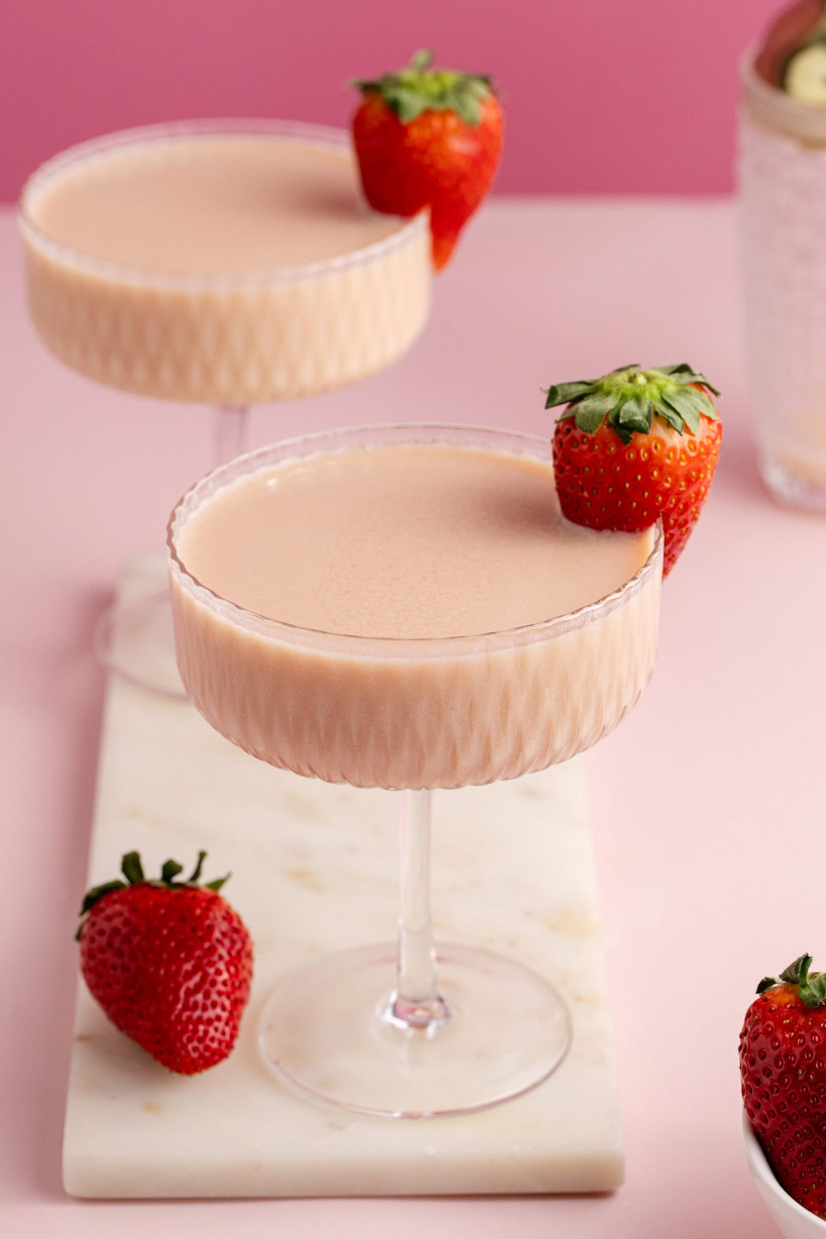 Strawberries and Cream Martini on a tray with a berry for garnish