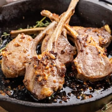 Pan Fried Lamb Chops in a skillet with garlic and thyme