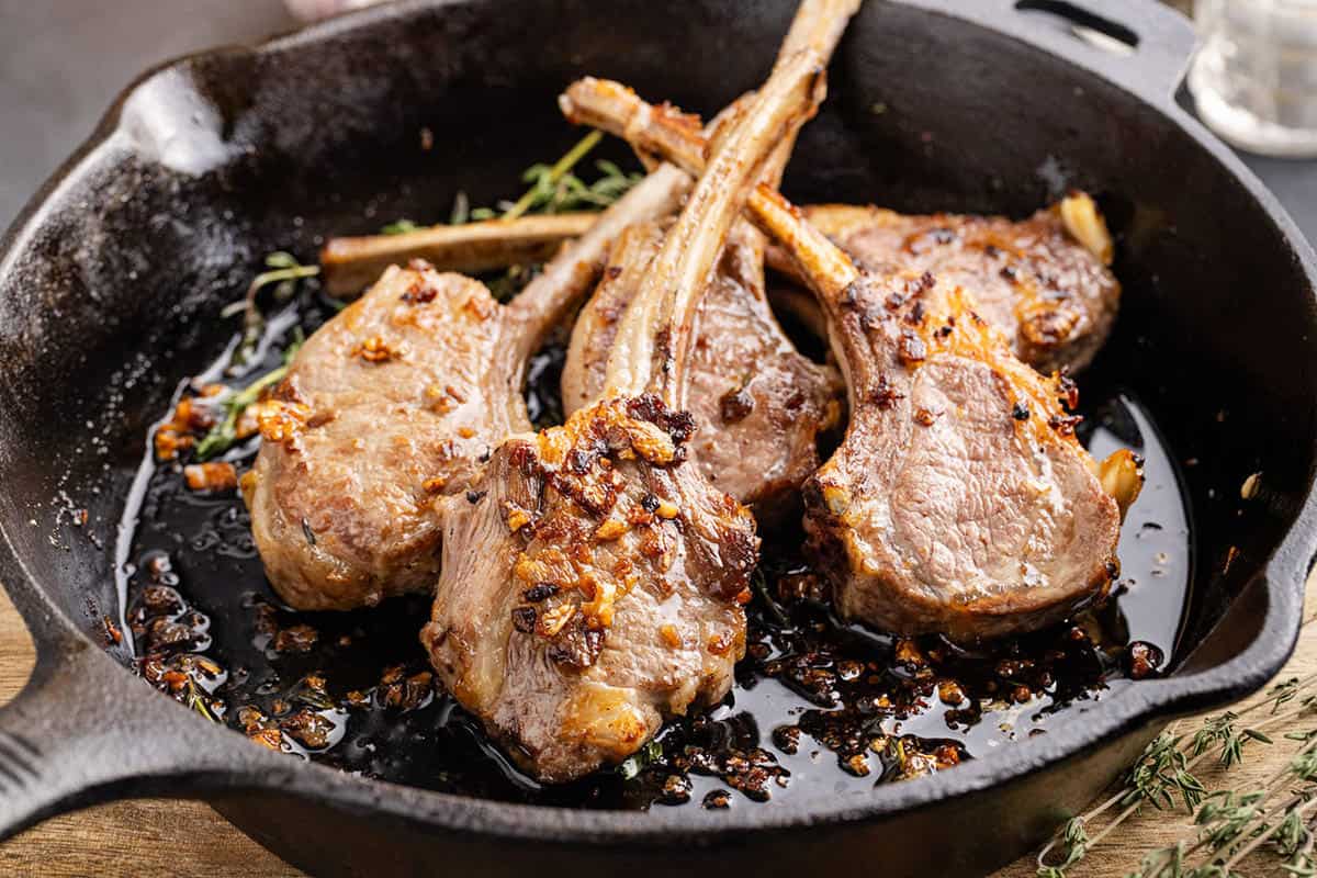 Pan Fried Lamb Chops in a skillet with garlic and thyme