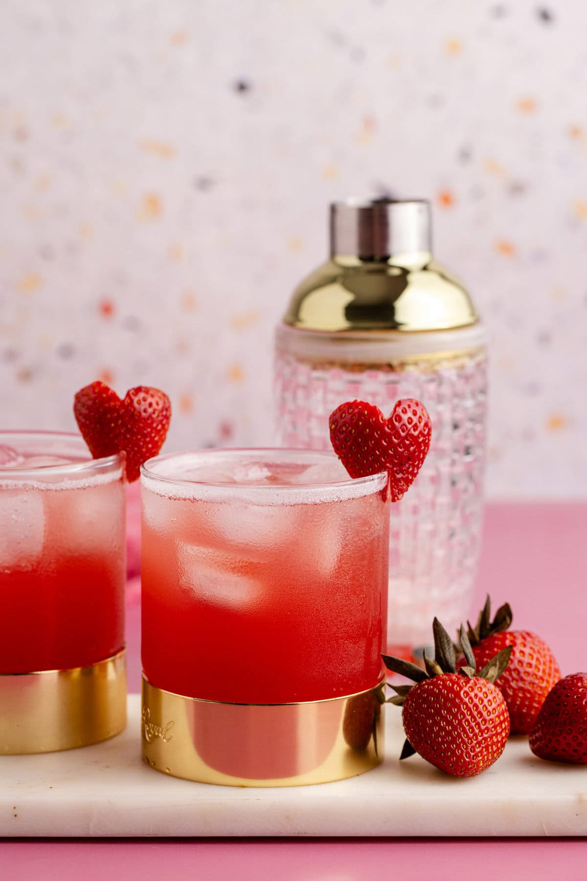 Love Bug Cocktail on a tray with berries and a shaker in the back