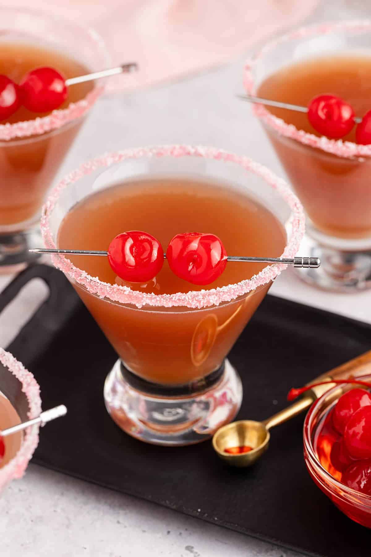 Love Potion Cocktail with a pink rim and cherry garnish