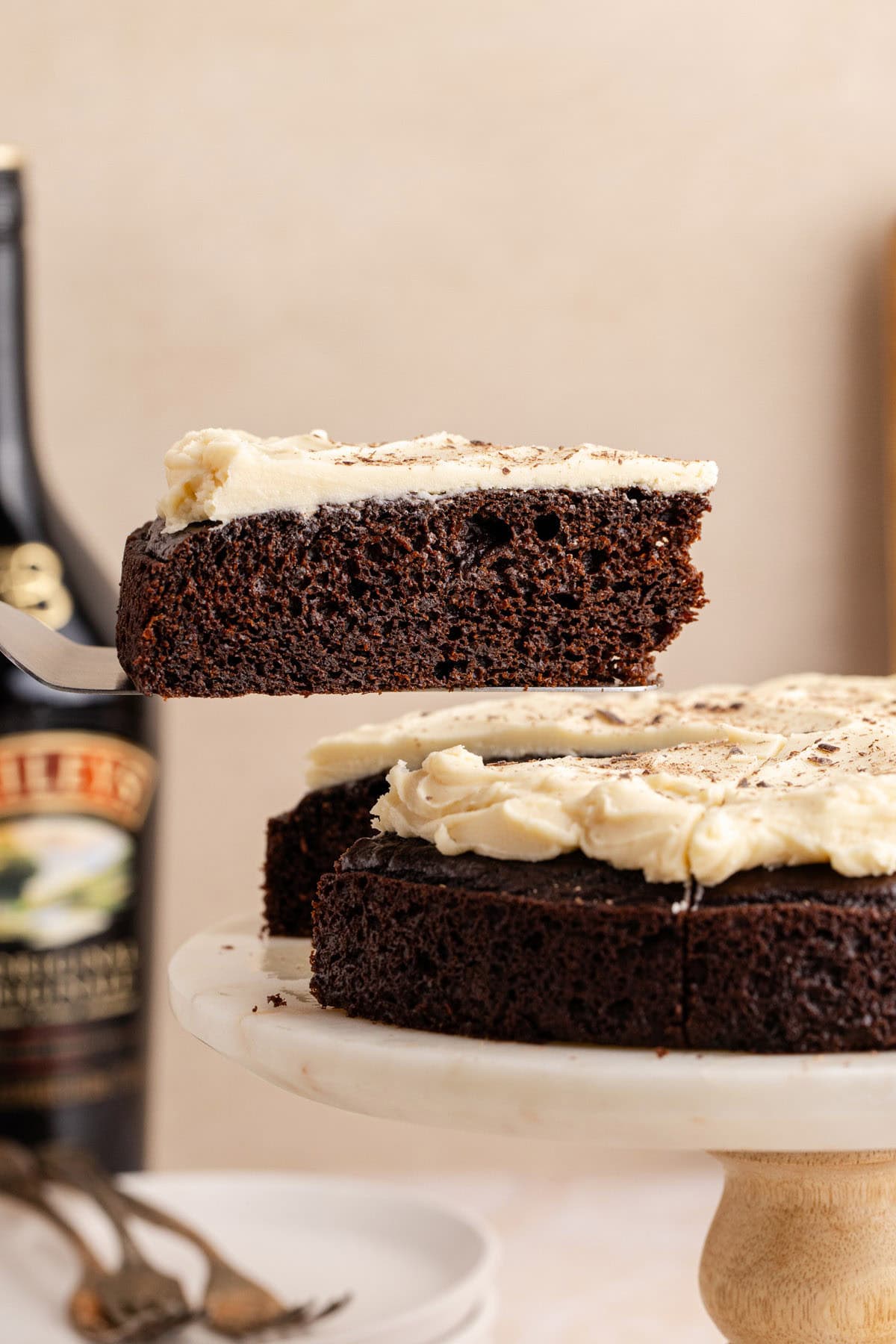 Baileys Irish Cream Cake on a cake stand and a slice above it on a cake server
