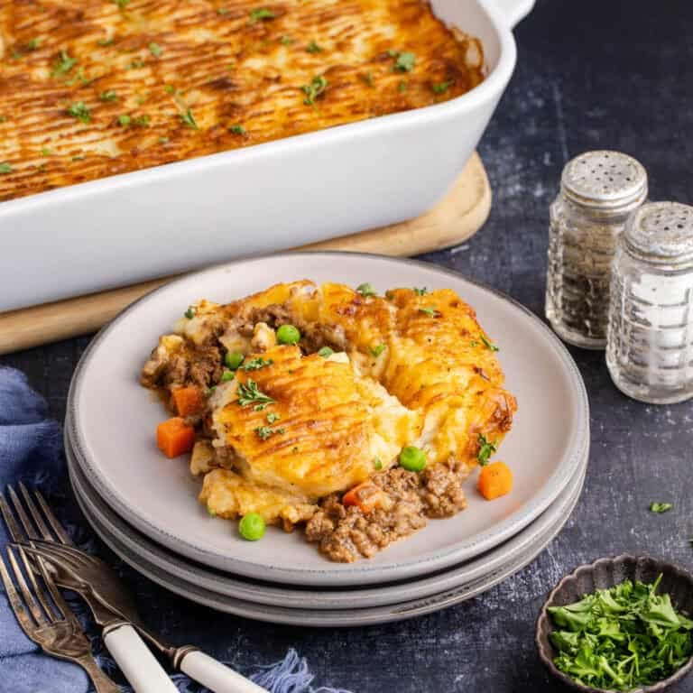 Cottage Pie Recipe on a plate and the casserole dish in the back