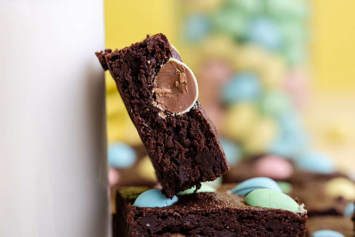 Easter Brownies stacked with one leaning on a glass of milk
