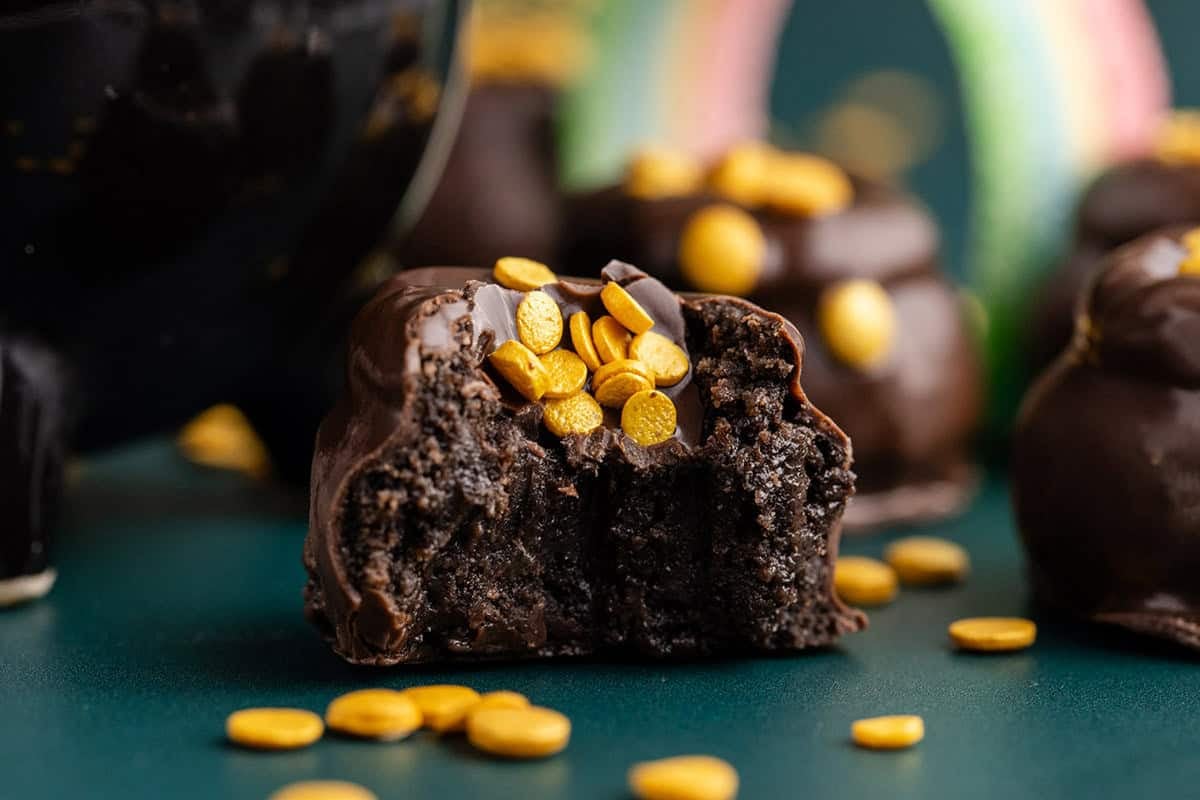 Mint Truffles with gold coin sprinkles on a counter with a bite taken