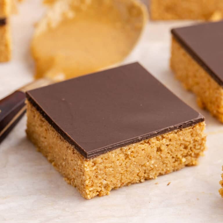 No Bake Peanut Butter Bars on parchment with a spoon behind