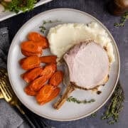 Pork Prime Rib on a plate with carrots and mashed potatoes