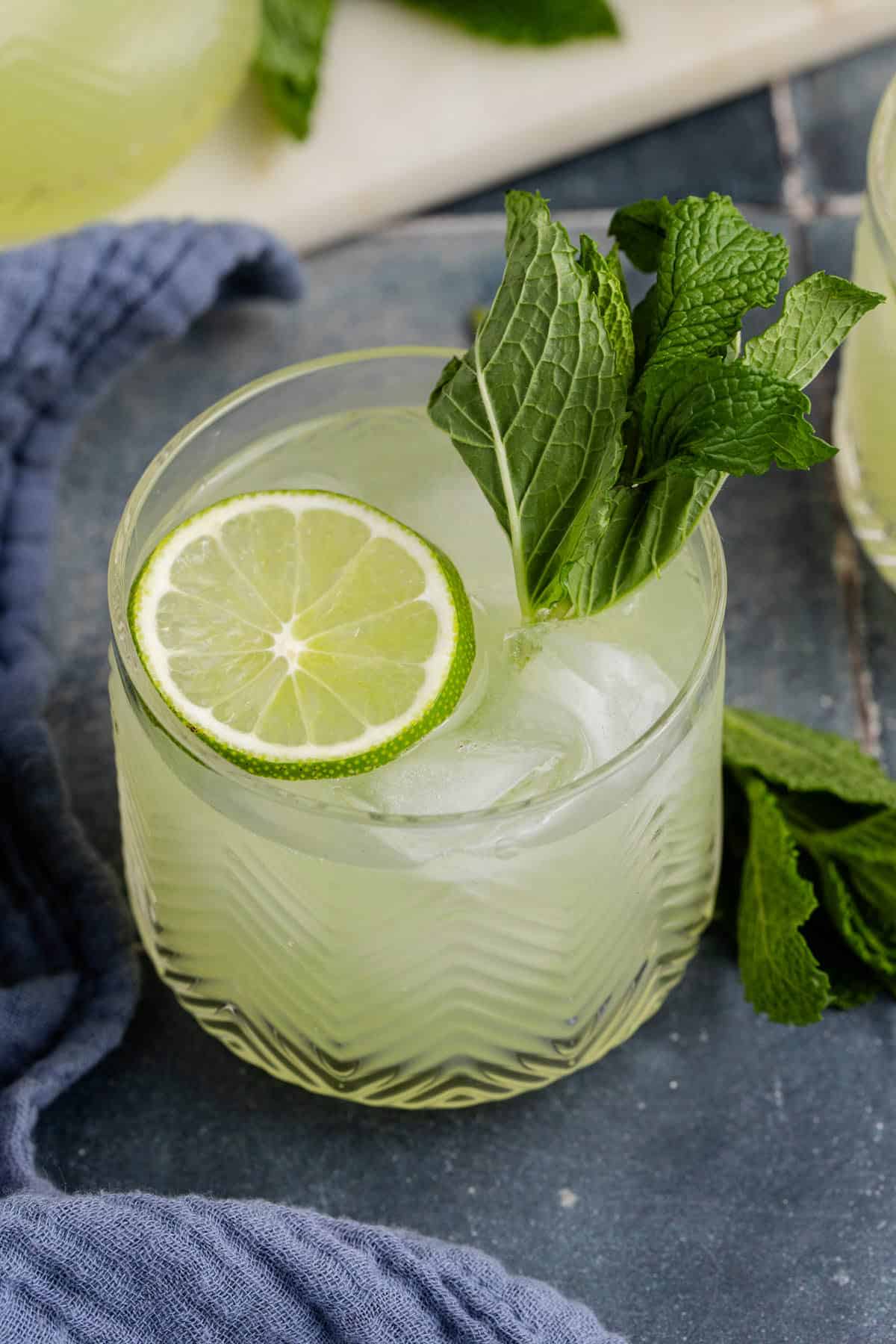 Cucumber Agua Fresca on a counter with limes and mint from above up close