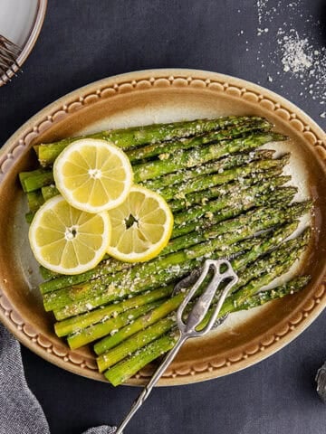 Garlic Parmesan Asparagus with lemon slices and cheese