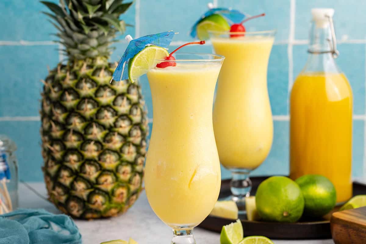 Non Alcoholic Frozen Pineapple Daiquiris with a pineapple in the back