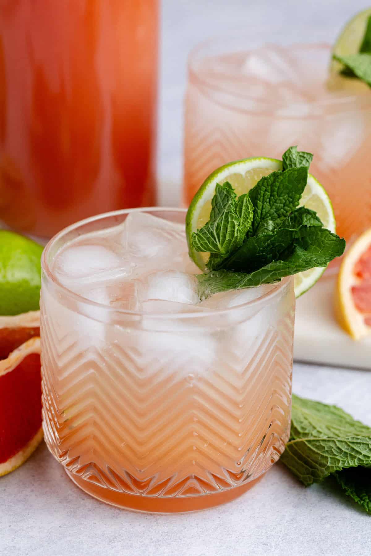 Non Alcoholic Paloma on a with mint and limes for garnish