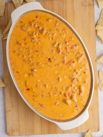 Spicy Sausage Queso in an oval dish from above with corn chips all around