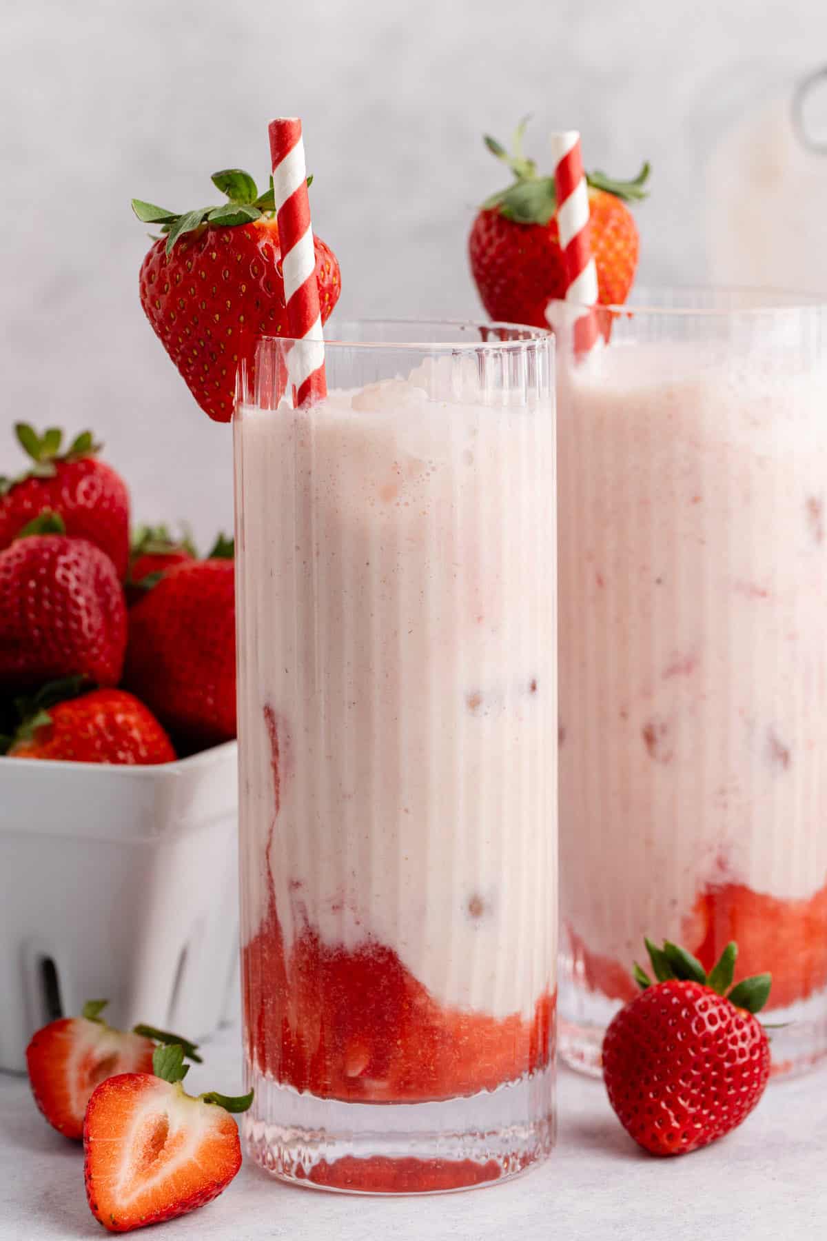 Strawberry Horchata on a counter with a basket of berries in the back