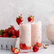 Strawberry Horchata on a counter with a basket of berries