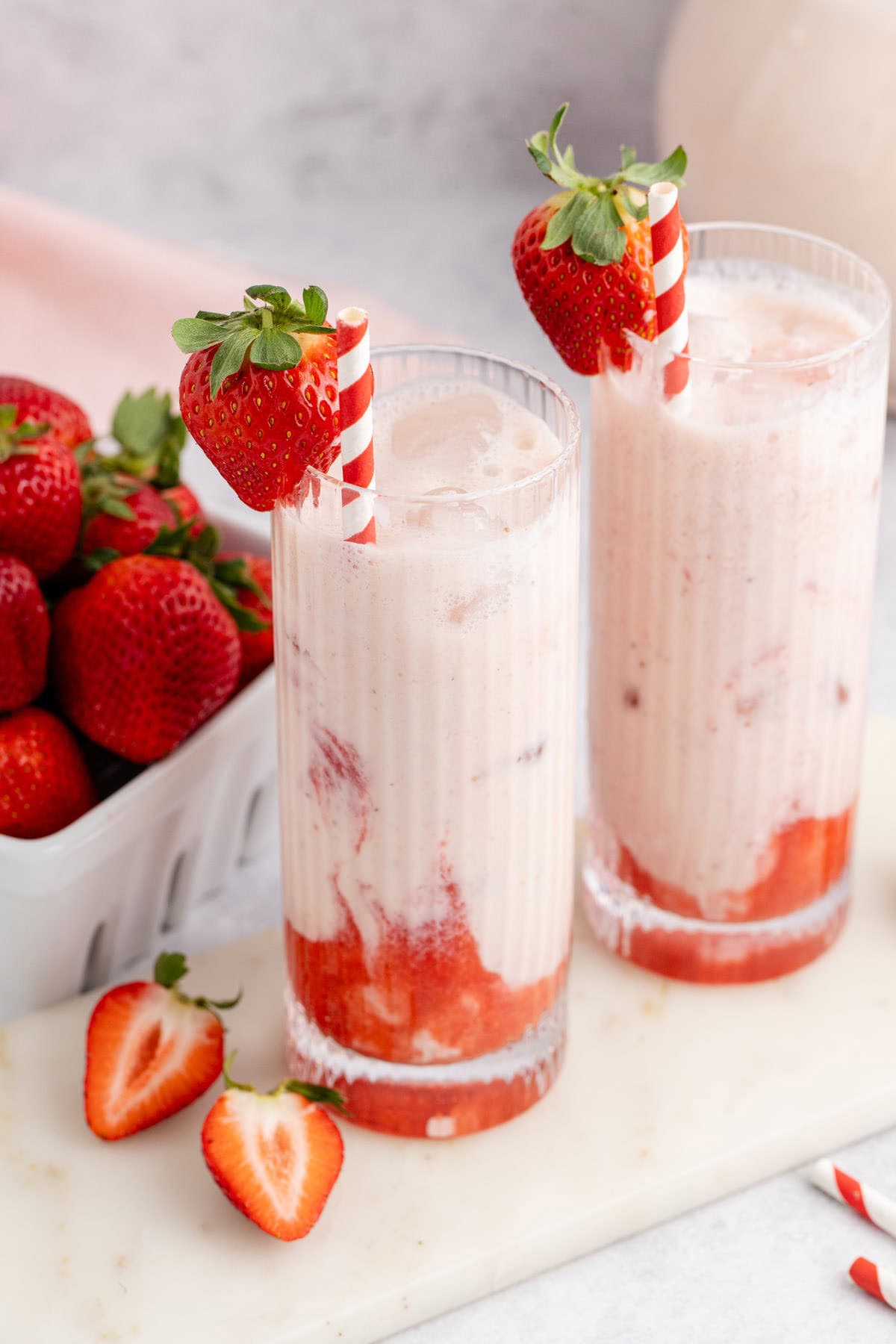 Strawberry Horchata with a strawberry garnish and red striped straw
