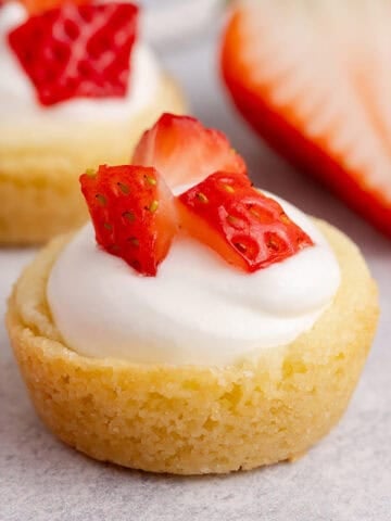 Strawberry Shortcake Cookie Cups up close with strawberries in the back