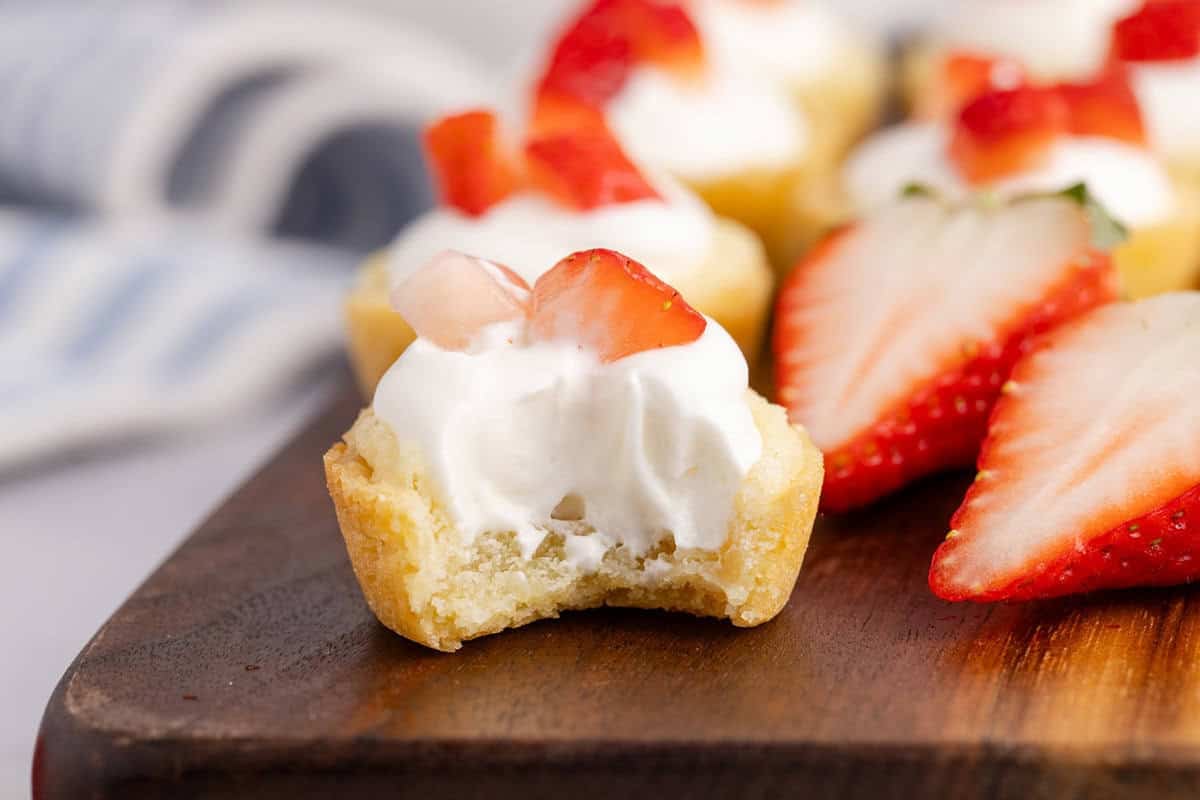 Strawberry Shortcake Cookie Cup on a cutting board with a bite taken