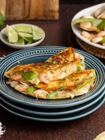 Tacos Gobernado on a plate with limes in the back