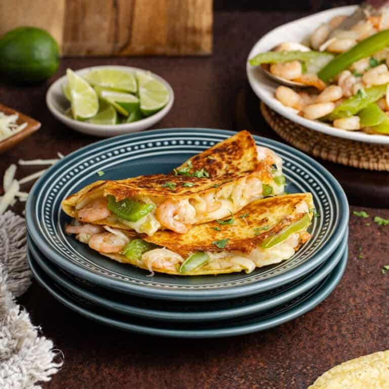 Tacos Gobernado on a plate with limes in the back