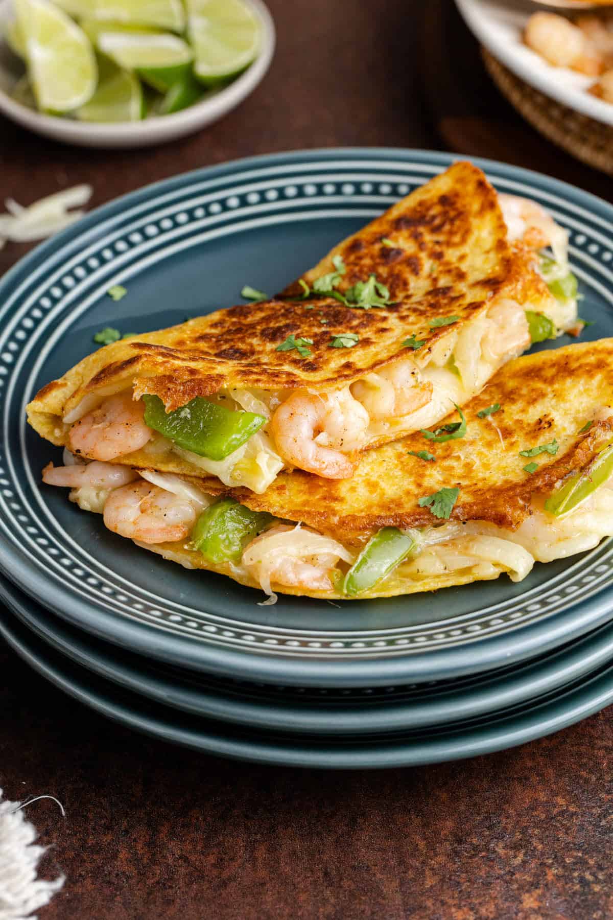 Tacos Gobernado on a plate with limes in the back