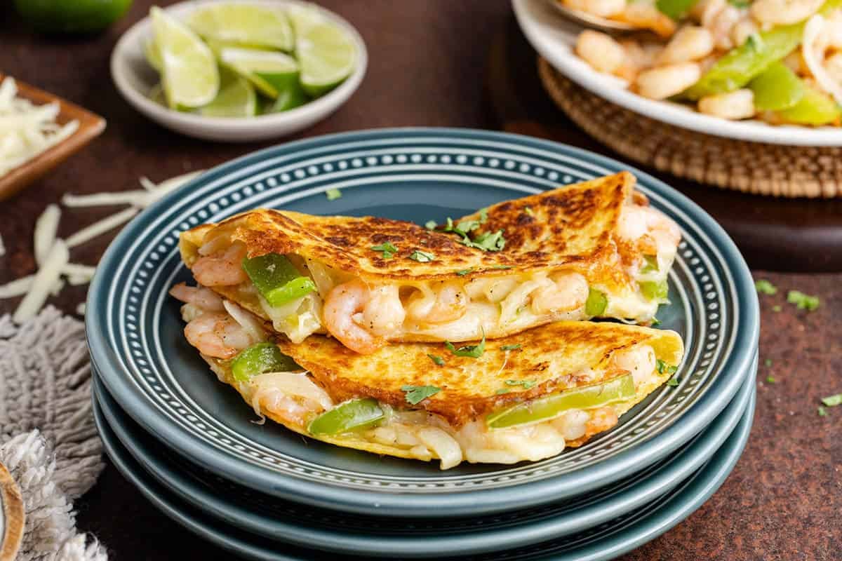 Tacos Gobernado on a plate with limes in the back