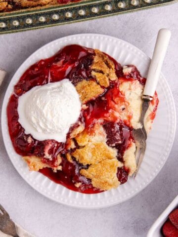 Strawberry Dump Cake from above with a fork and ice cream on the plate