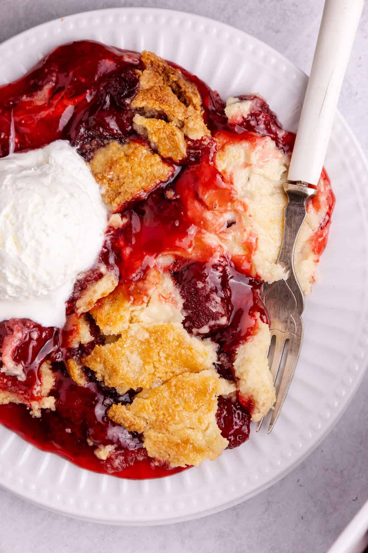Strawberry Dump Cake from above up close with a fork on the plate