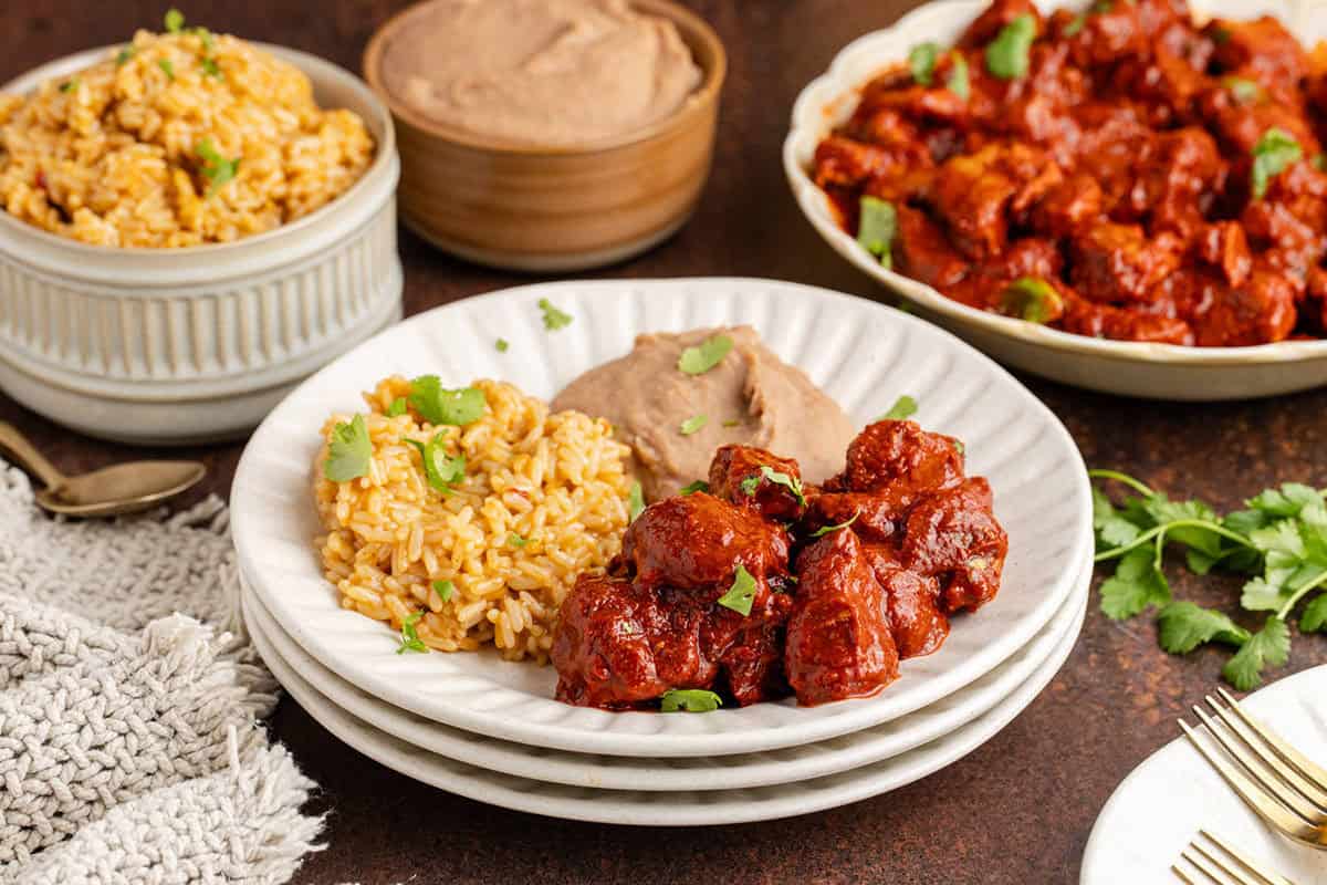Asado de Puerco on a plate with rice and beans