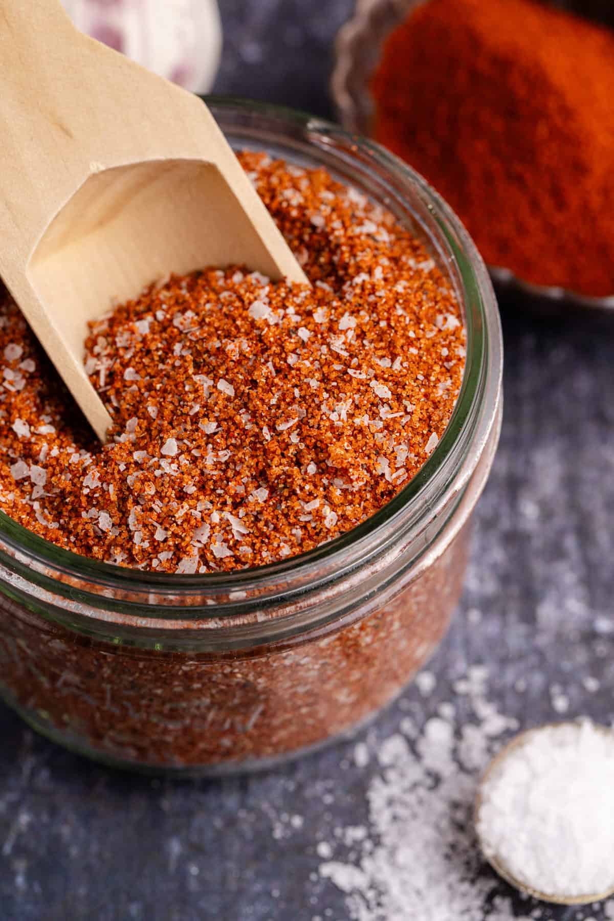 Brisket Rub in a small mason jar and a small wooden spoon sticking out