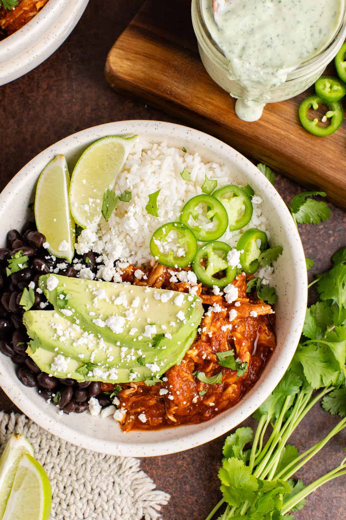 Chicken Tinga bowl from above garnished with cilantro, avocado and jalapeños