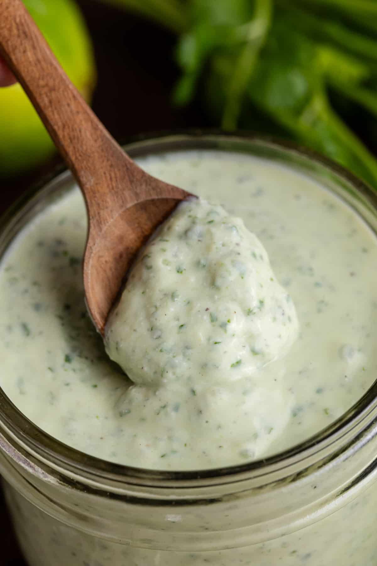 Cilantro Lime Dressing in a jar with a spoonful overtop