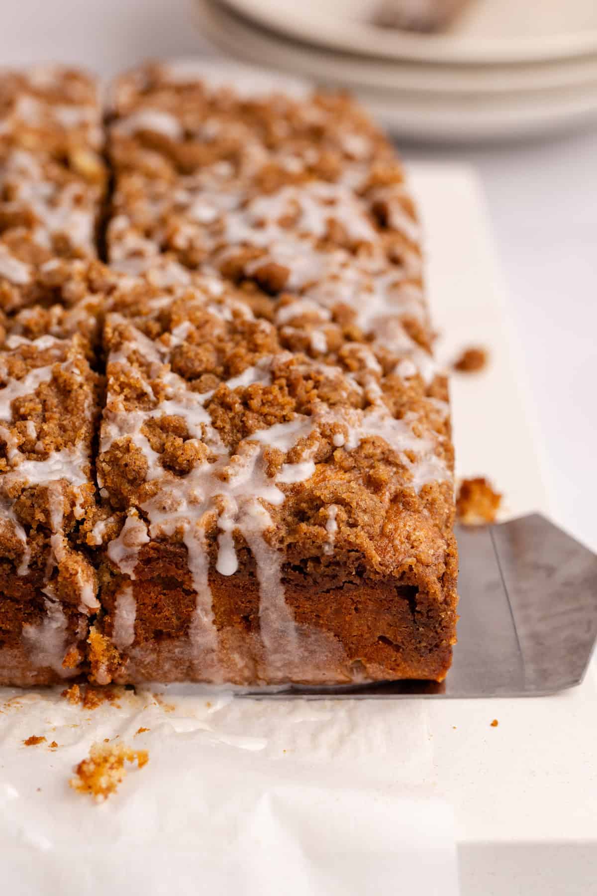 Cinnamon coffee cake slice about to be picked up with a server