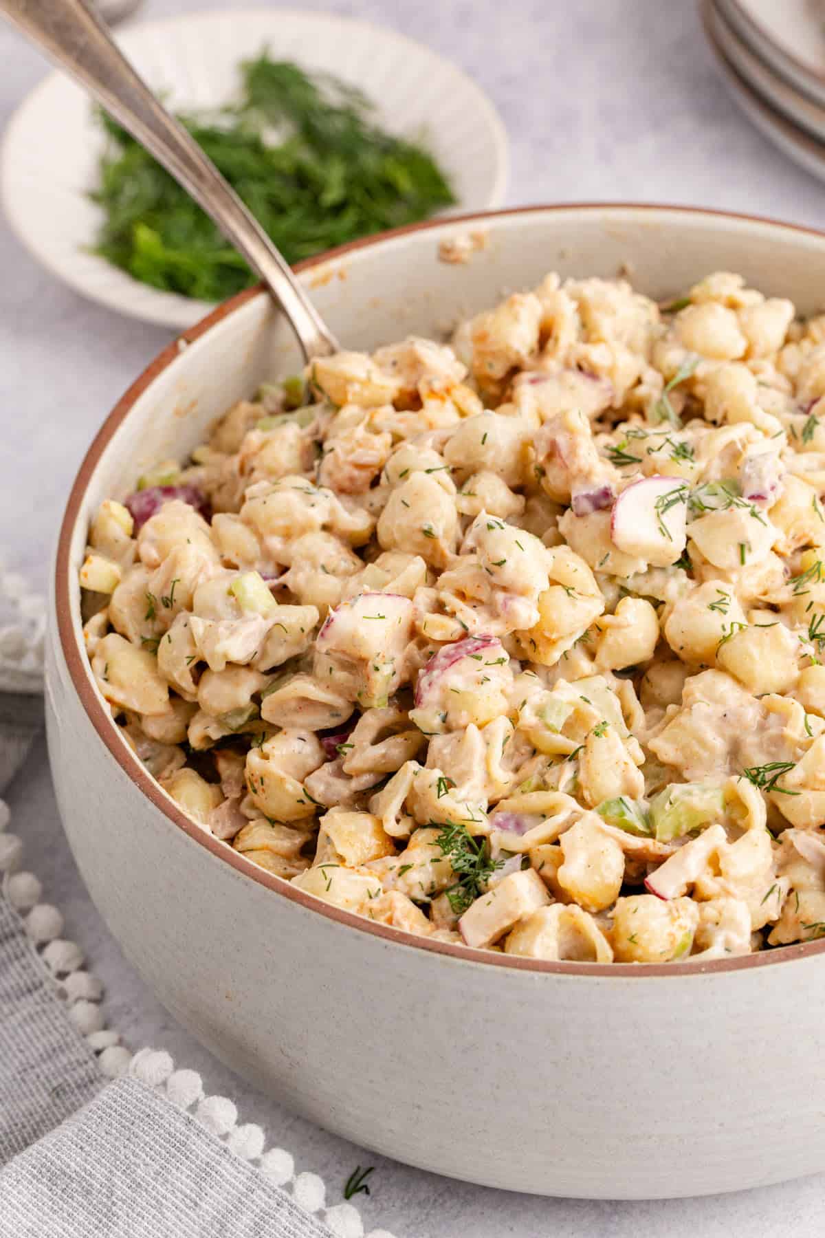 Cold Tuna Pasta Salad in a serving bowl with a spoon in it