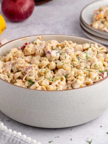 Cold Tuna Pasta Salad in a serving bowl with a plateful in the back