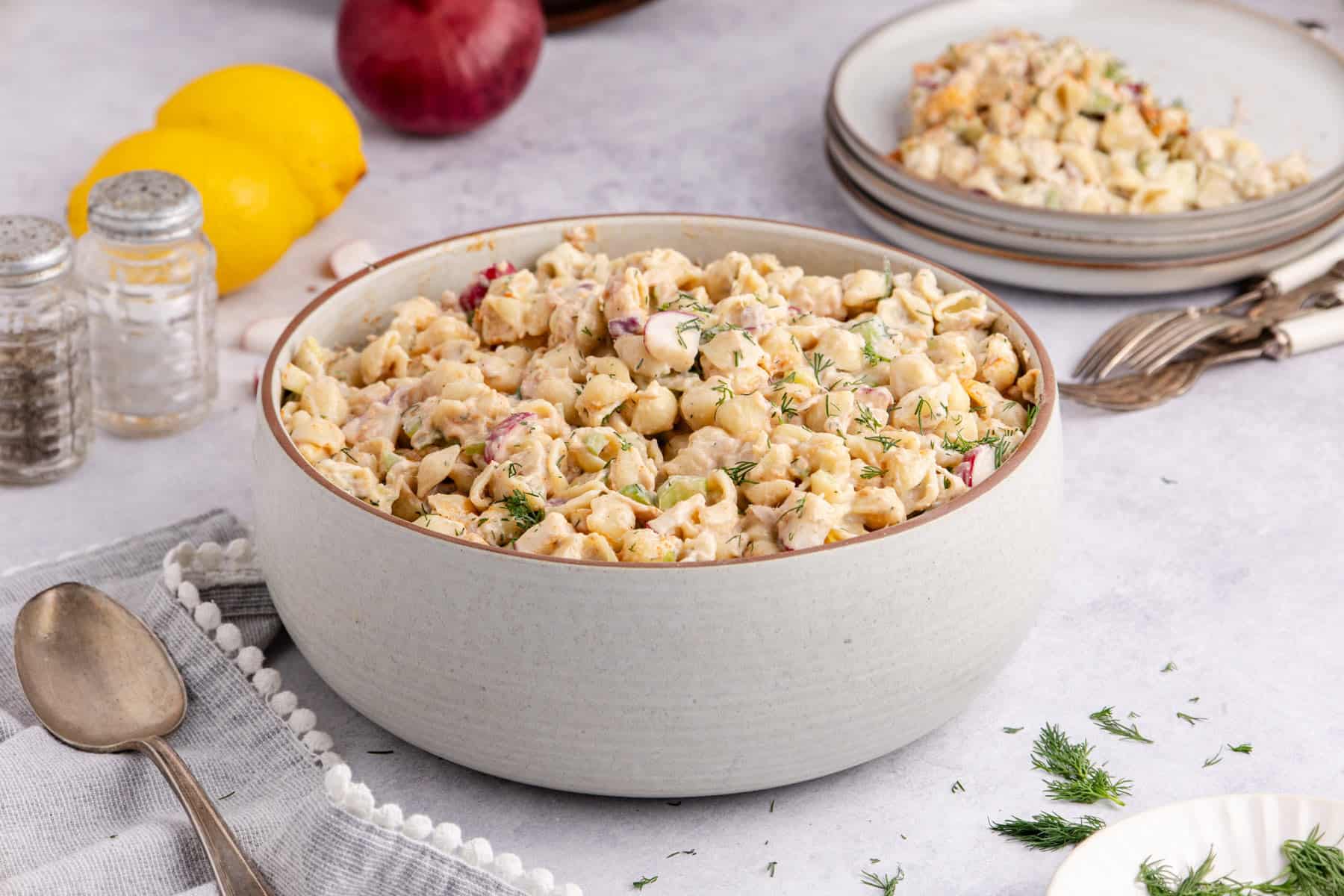 Cold Tuna Pasta Salad in a serving bowl with a plateful in the back