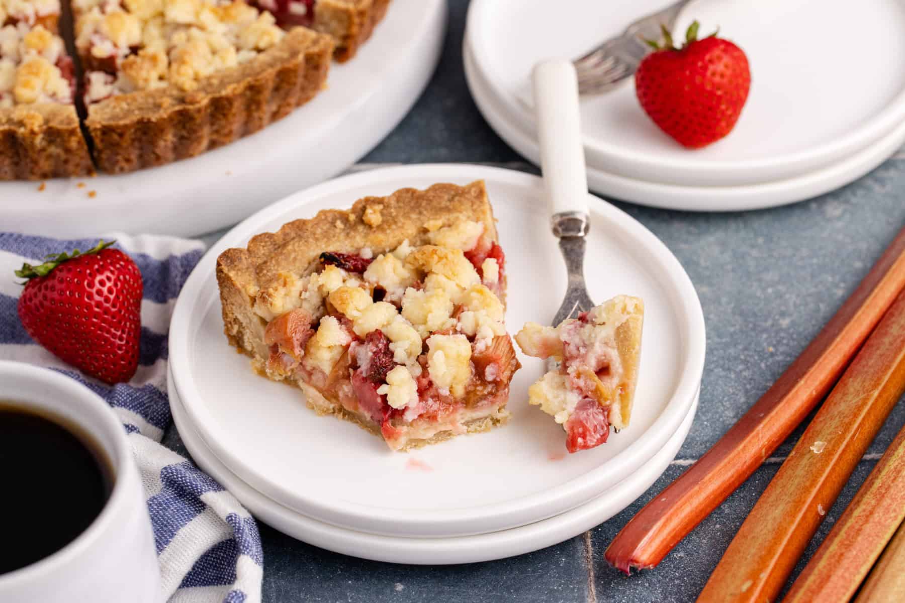 Strawberry Rhubarb Tart on a plate with a piece on a fork