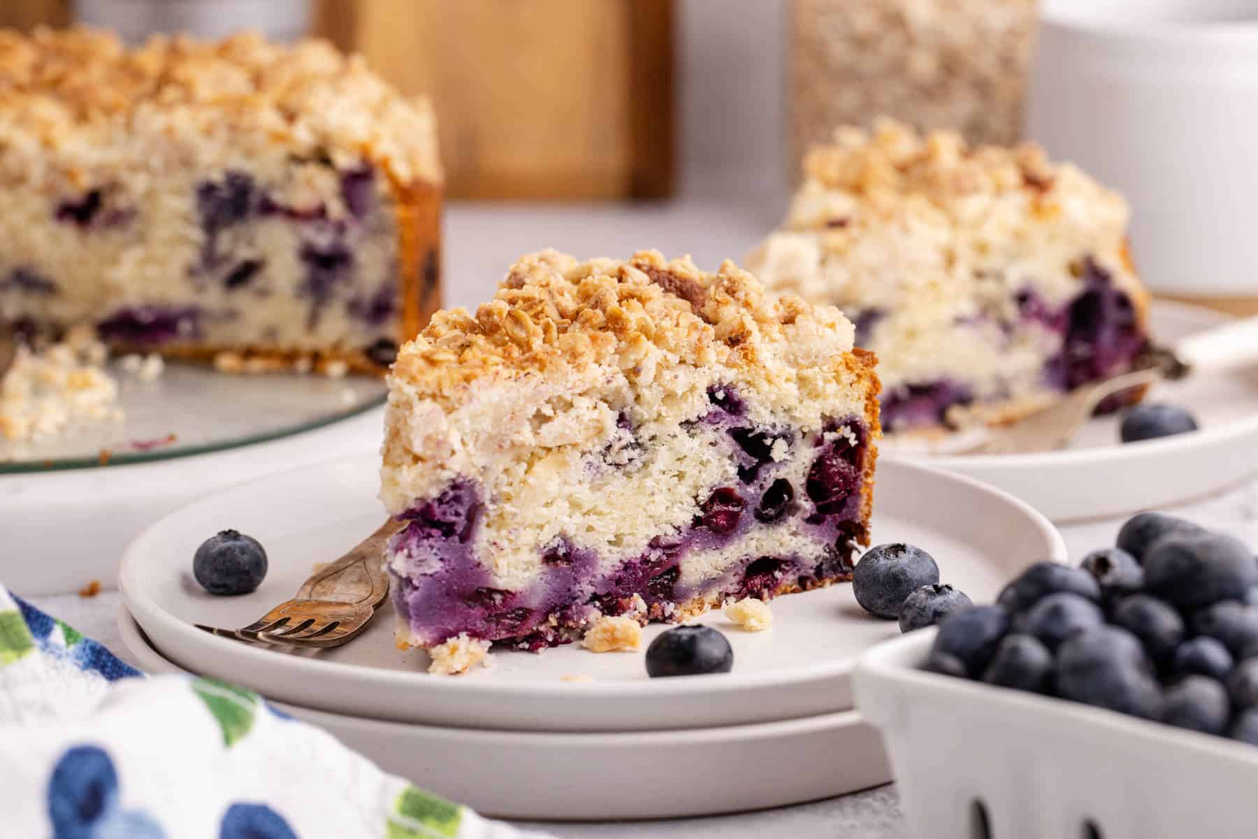 Blueberry Coffee Cake on plates with fresh blueberries