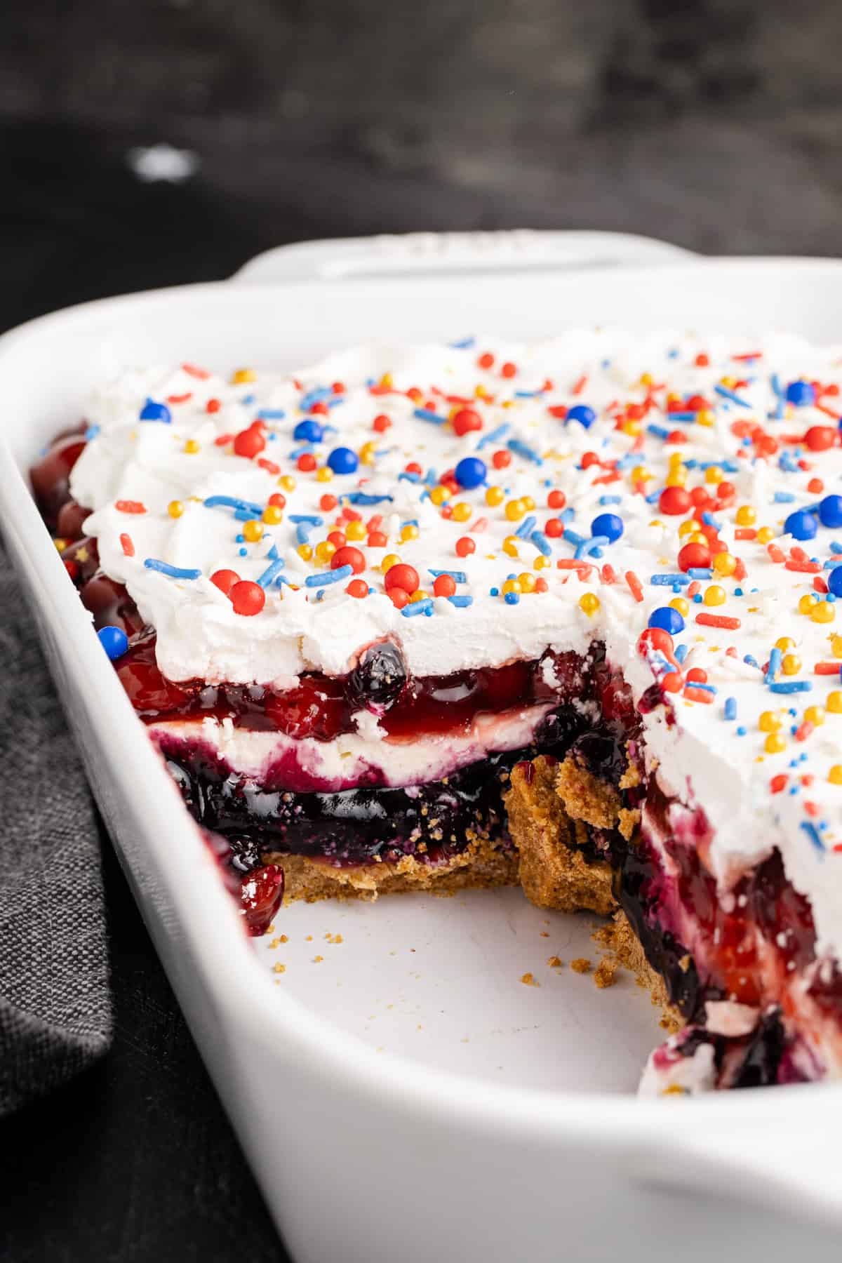 Red White and Blue Dessert Lasagna in a baking dish with a slice missing showing the layers