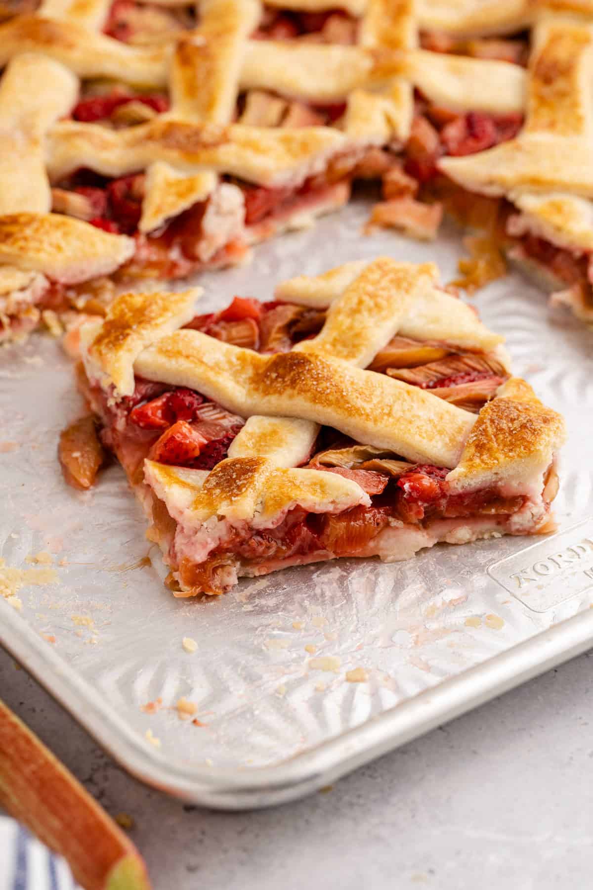 Strawberry Rhubarb Slab Pie slice on on a sheet pan