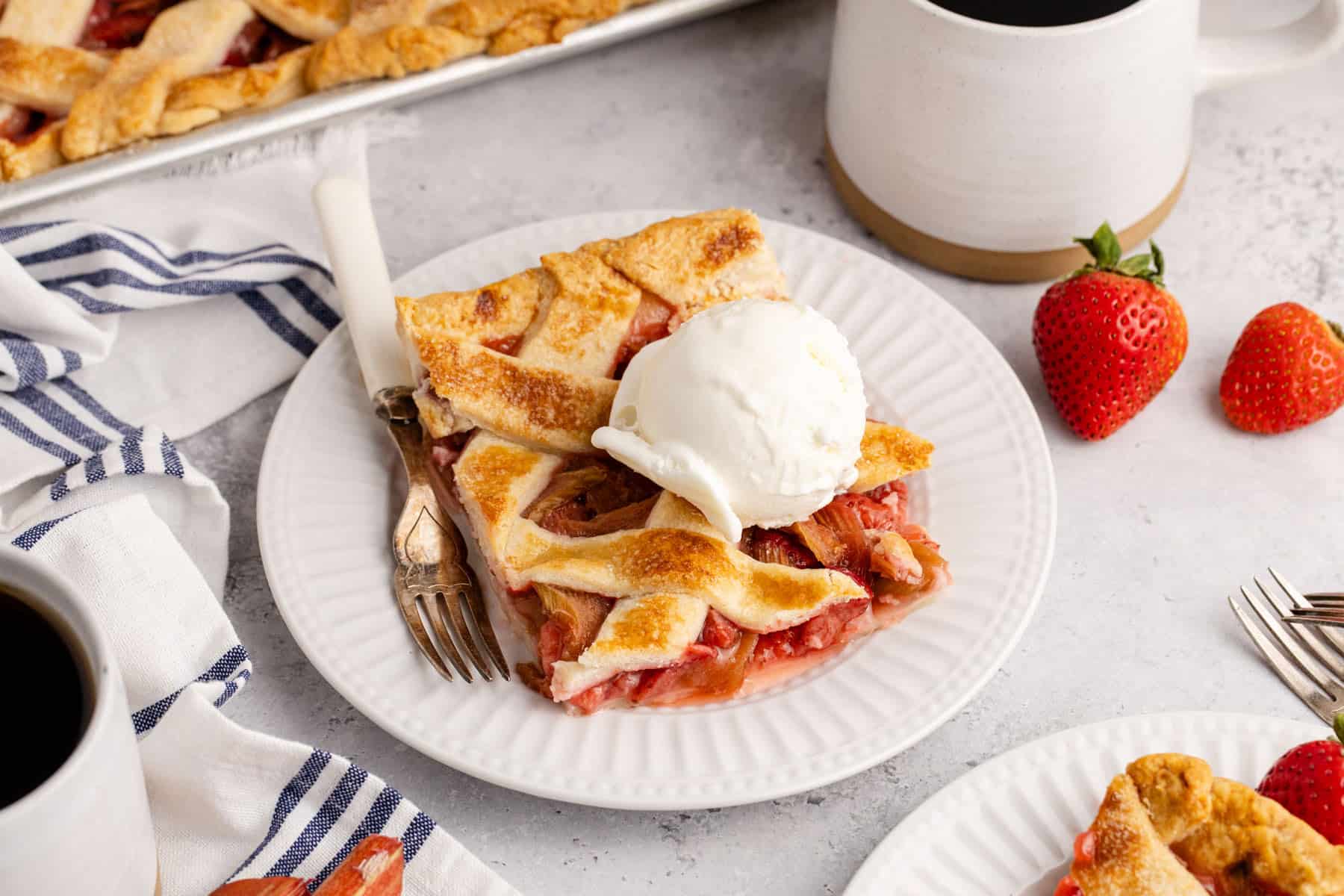 Strawberry Rhubarb Slab Pie on a plate with ice cream